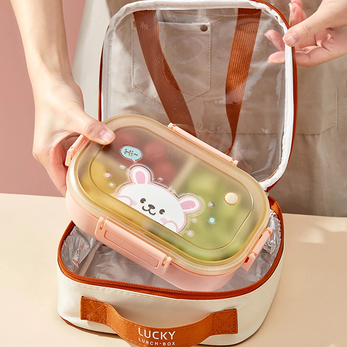 Lunch box with kawaii cartoon design held by a person, against a neutral background