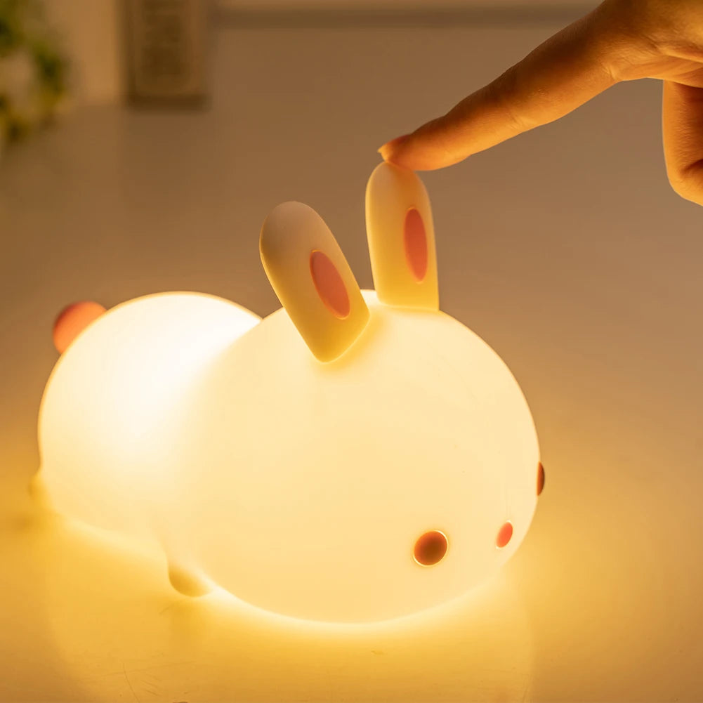 Cute rabbit-shaped kawaii night light being held by a hand with a warm glow.
