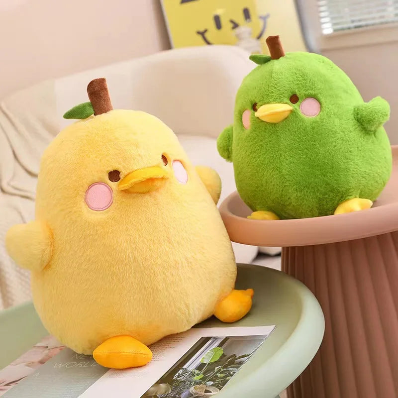Two kawaii plush toys, one yellow and one green, sitting on a table.