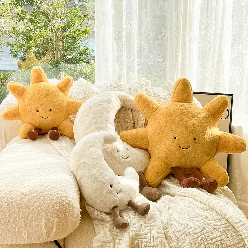 Two kawaii plush sun toys on a couch with a window in the background