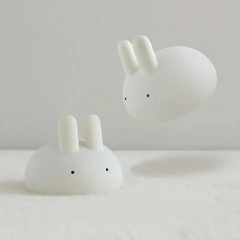 Two white rabbit-shaped kawaii night light on a light gray background