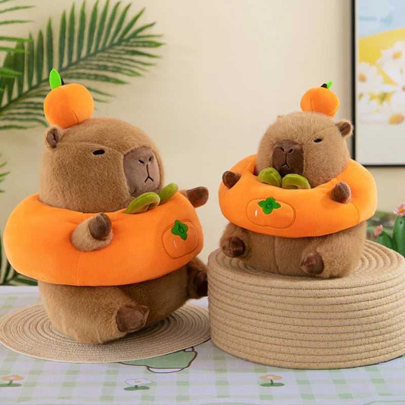 Two kawaii plush toys resembling beavers in orange outfits with pumpkin hats on a decorative surface.