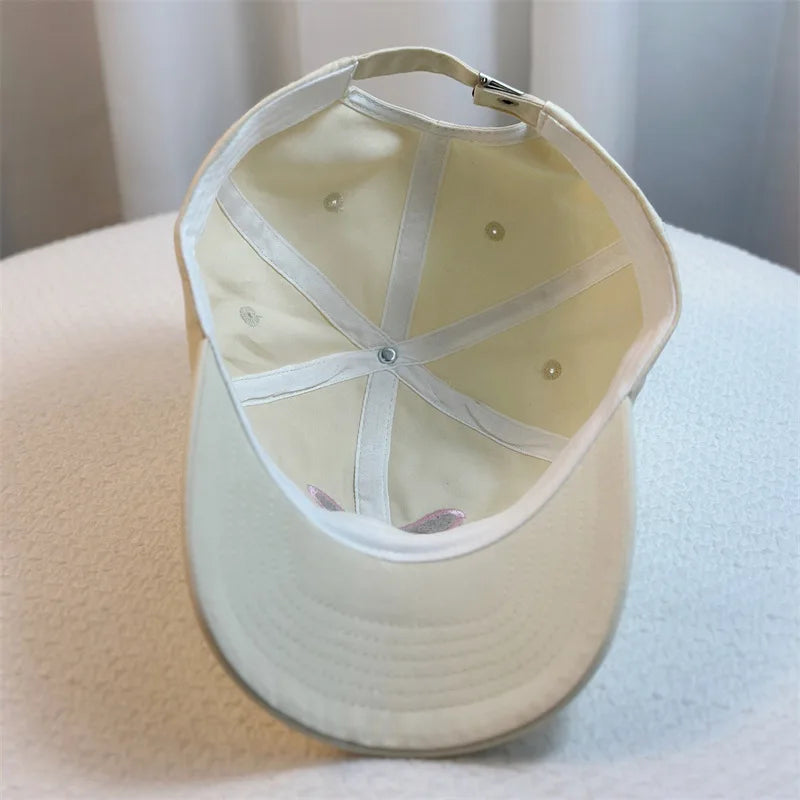 Beige Kawaii baseball cap with a white interior on a light surface