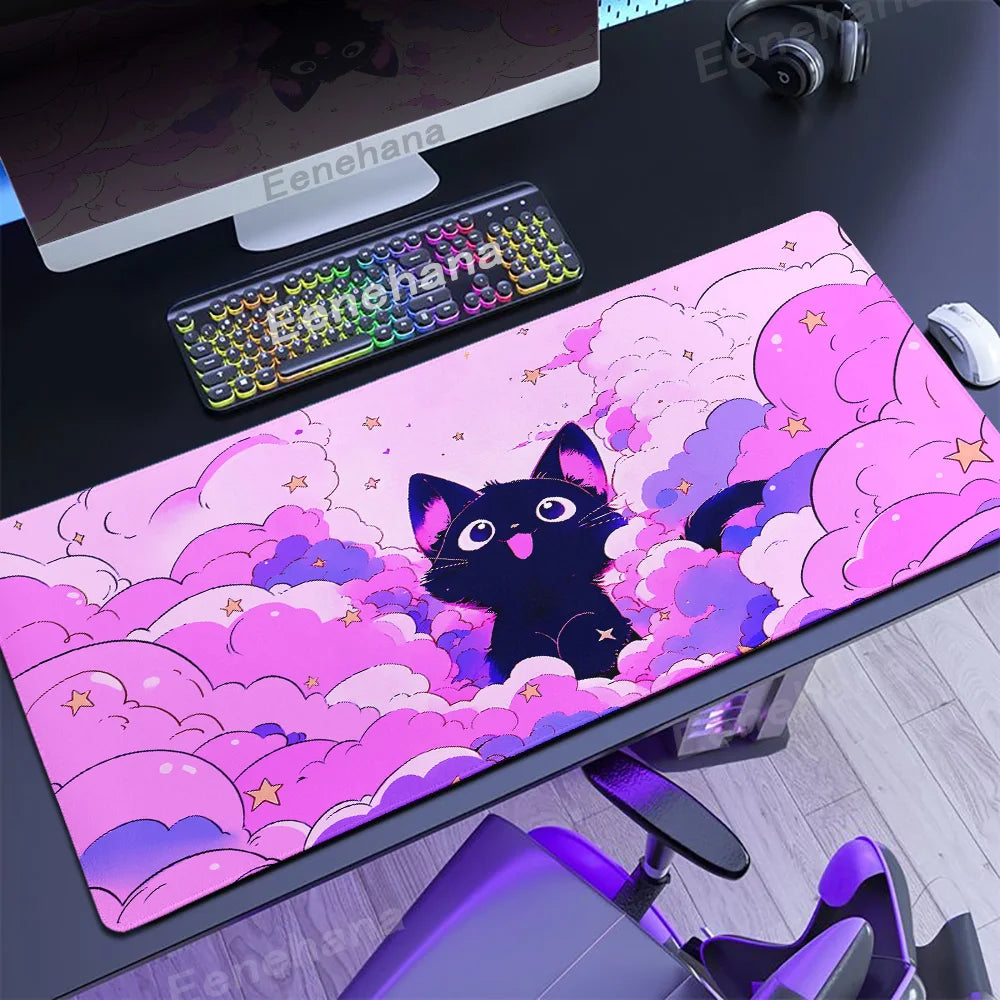 Desk setup with a pink desk mat featuring a Kawaii black cat design, keyboard, and computer monitor.