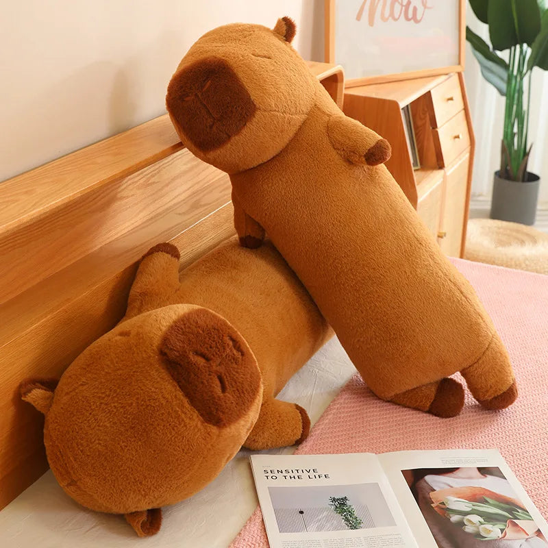 Two brown kawaii plush dog toys on a bed next to an open magazine.