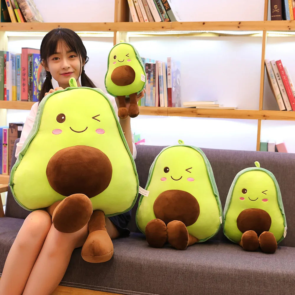 Person holding avocado-shaped kawaii plush toys in front of a bookshelf