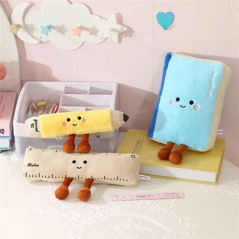 Three kawaii plush stationery items with faces on a desk with a pink wall background