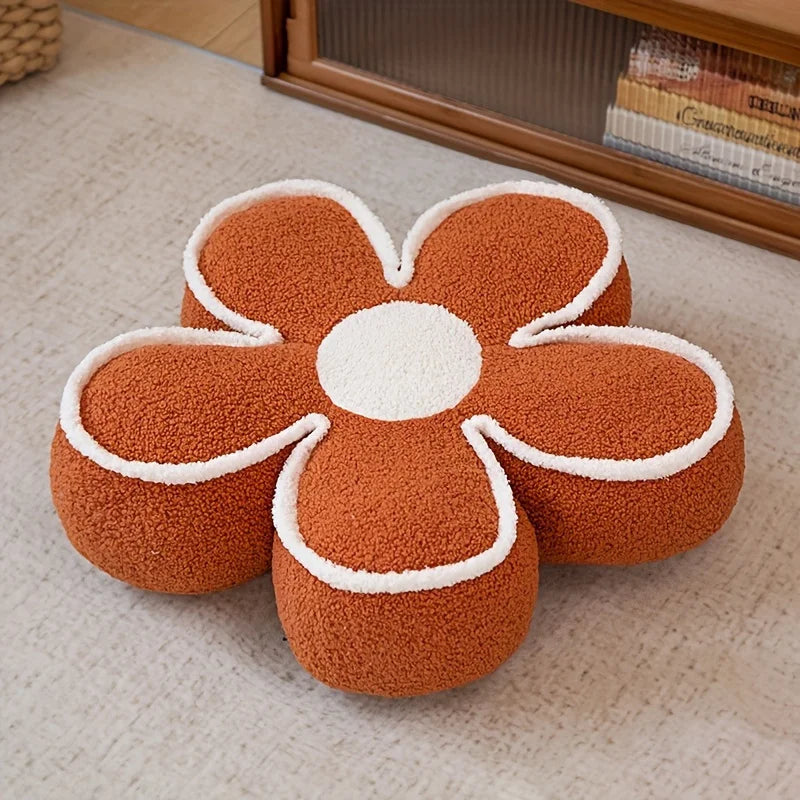 Flower-shaped kawaii cushion with brown and white colors on a carpeted floor.