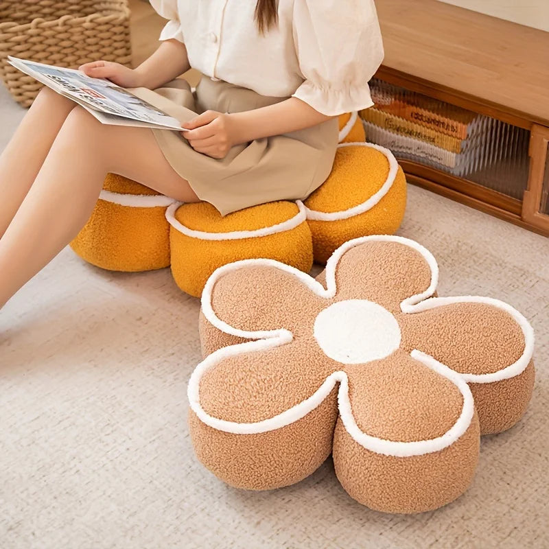 Person sitting on a flower-shaped kawaii cushion reading a newspaper, with more cushions in the background.