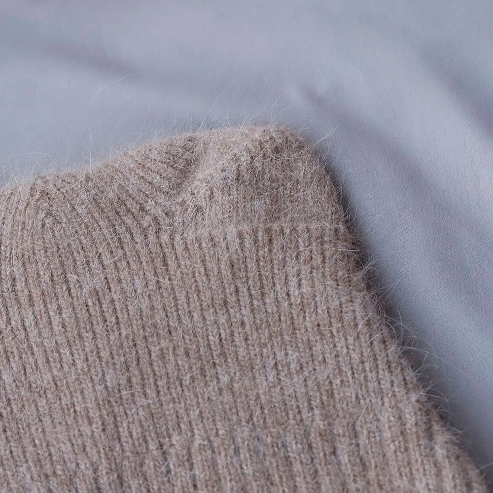Close-up of a textured beige Kawaii hat on a gray background