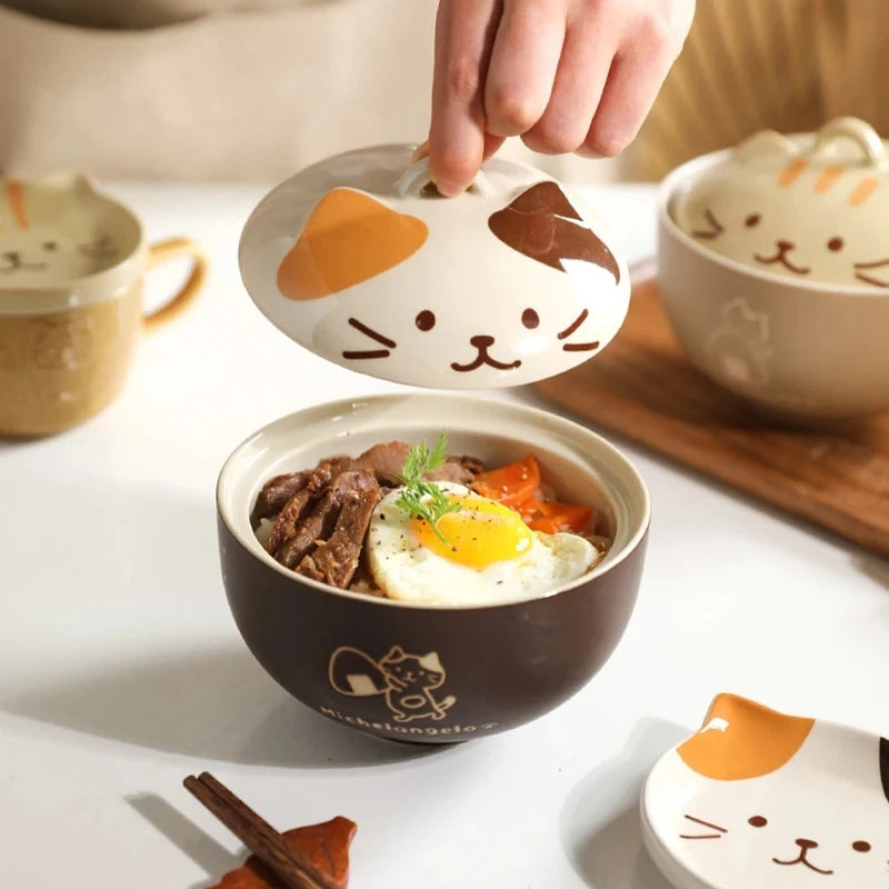 Cute kawaii cat-shaped lid being placed on a bowl of food with more cat-themed bowls in the background.