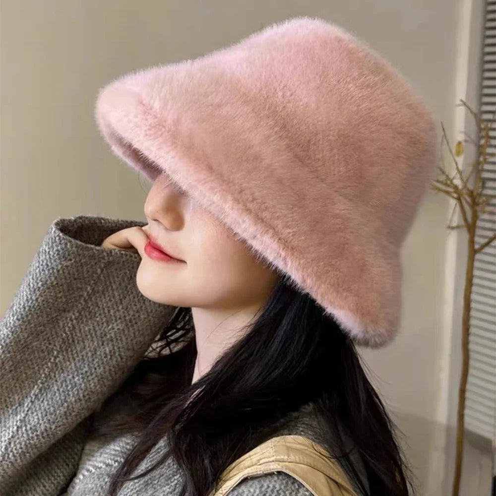 Person wearing a fluffy Kawaii pink hat and gray coat against a neutral background