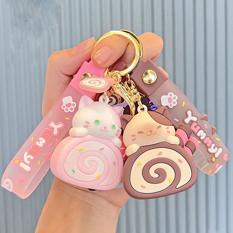 Cute keychain with kawaii cartoon characters and 'Yummy!' text held by a hand against a light blue background.