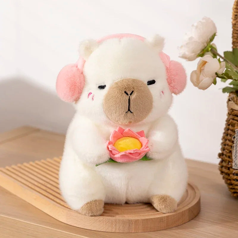 Kawaii plush toy sheep with pink ears and a flower on a wooden surface