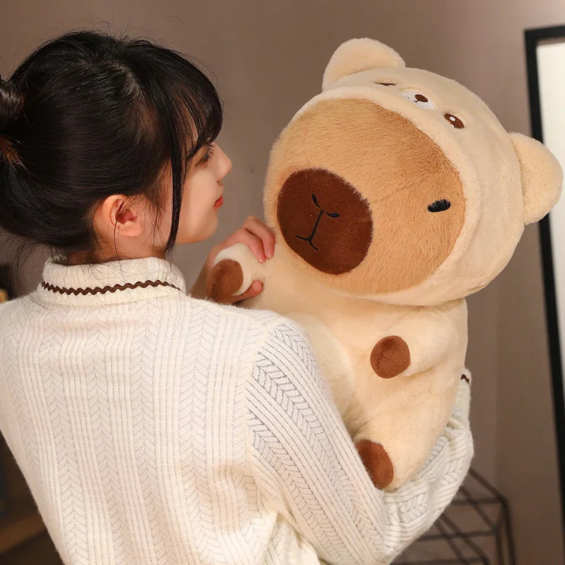 Person holding a large kawaii teddy bear in a room with a neutral background