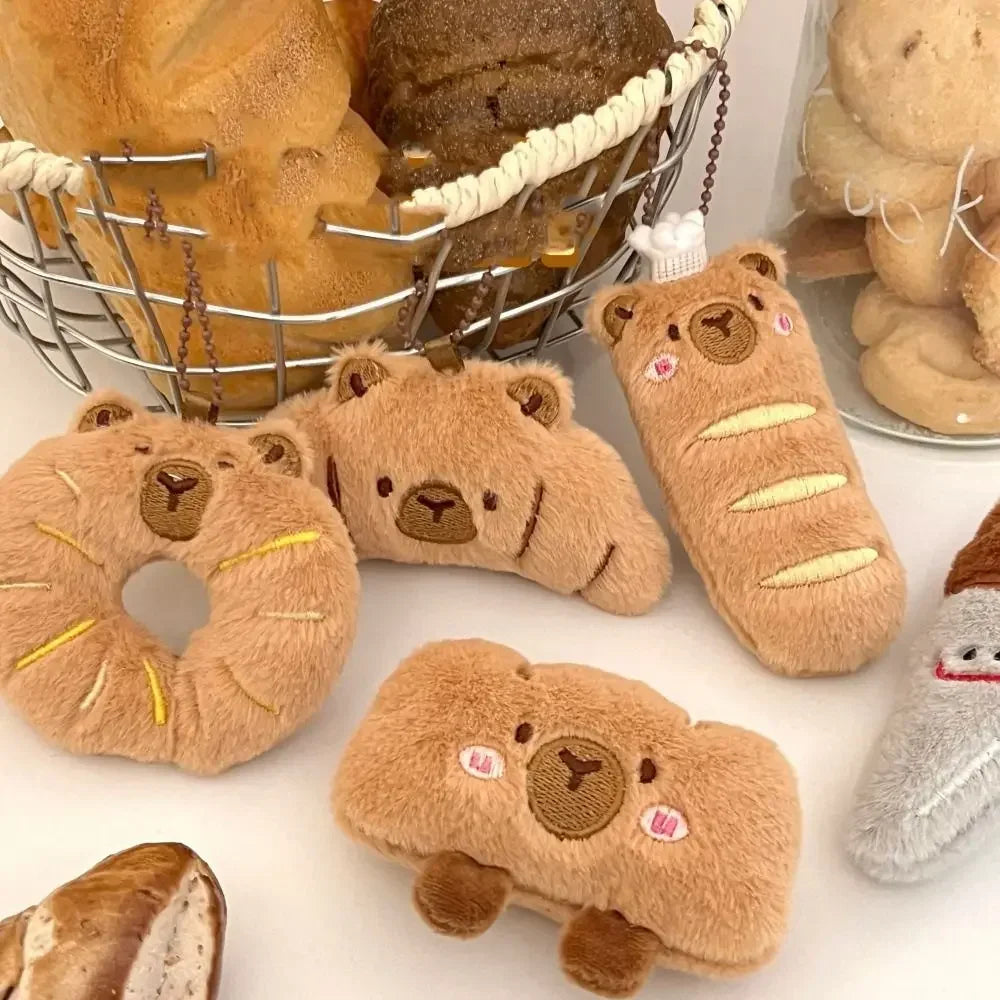Plush kawaii toys shaped like bread and donuts on a white surface with a basket of bread in the background.