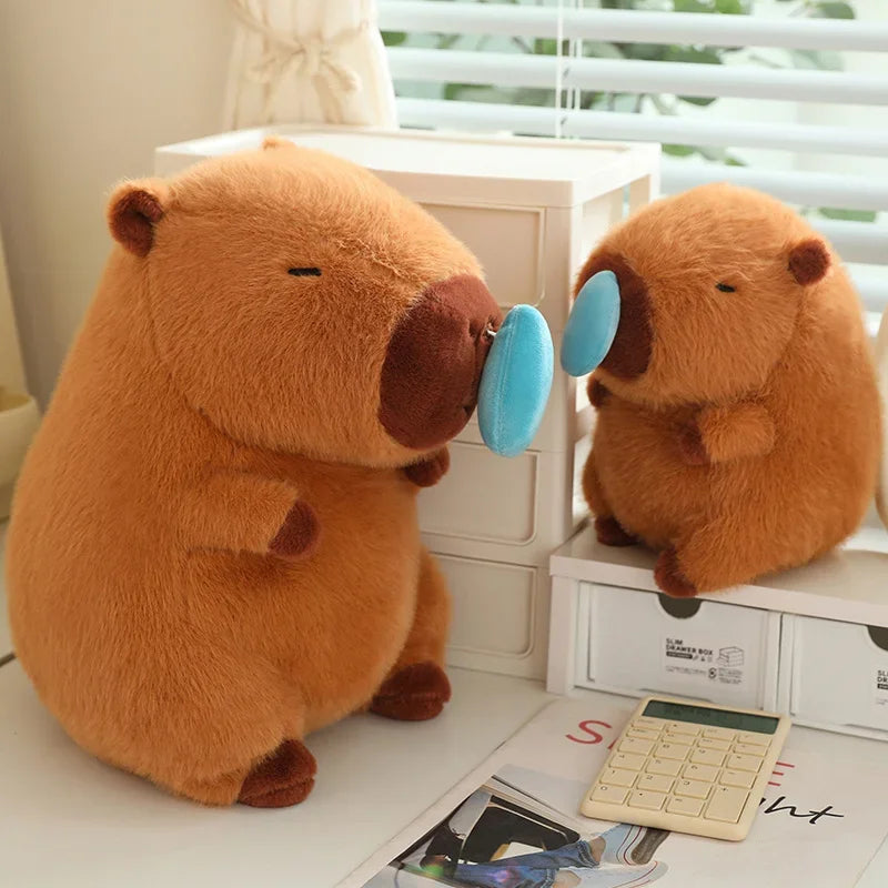 Two kawaii plush beavers with a blue bubble on a desk.