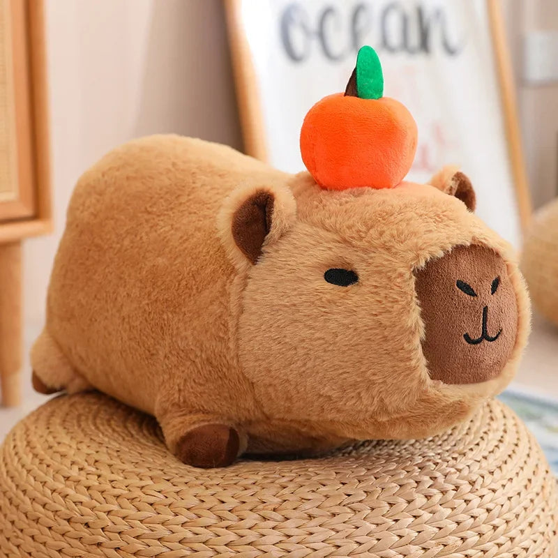 Plush kawaii toy resembling a guinea pig with a pumpkin on its head, sitting on a woven surface.