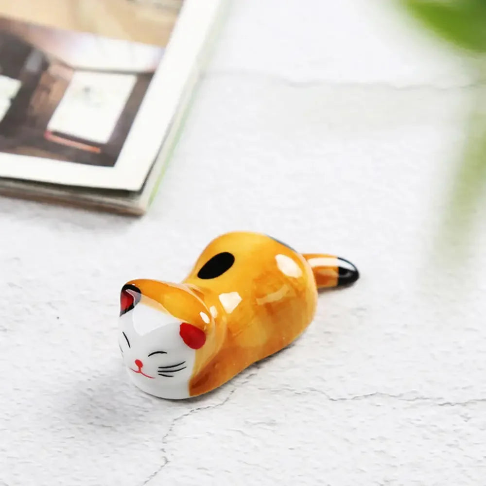Kawaii cat-shaped ceramic ornament on a light surface