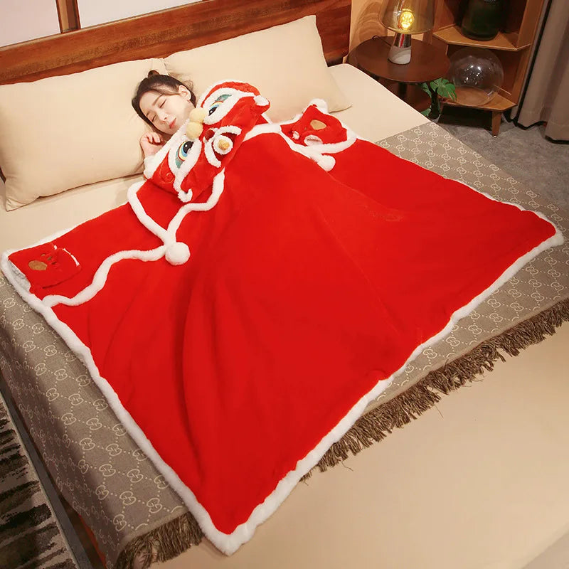 Person sleeping under a red blanket with kawaii cartoon face design on a bed.