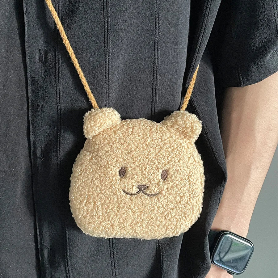 Beige Kawaii bear-shaped bag worn over shoulder with person wearing a black coat