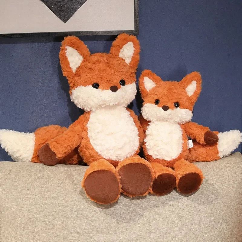 Two plush fox kawaii toys sitting on a surface with a blue wall in the background.