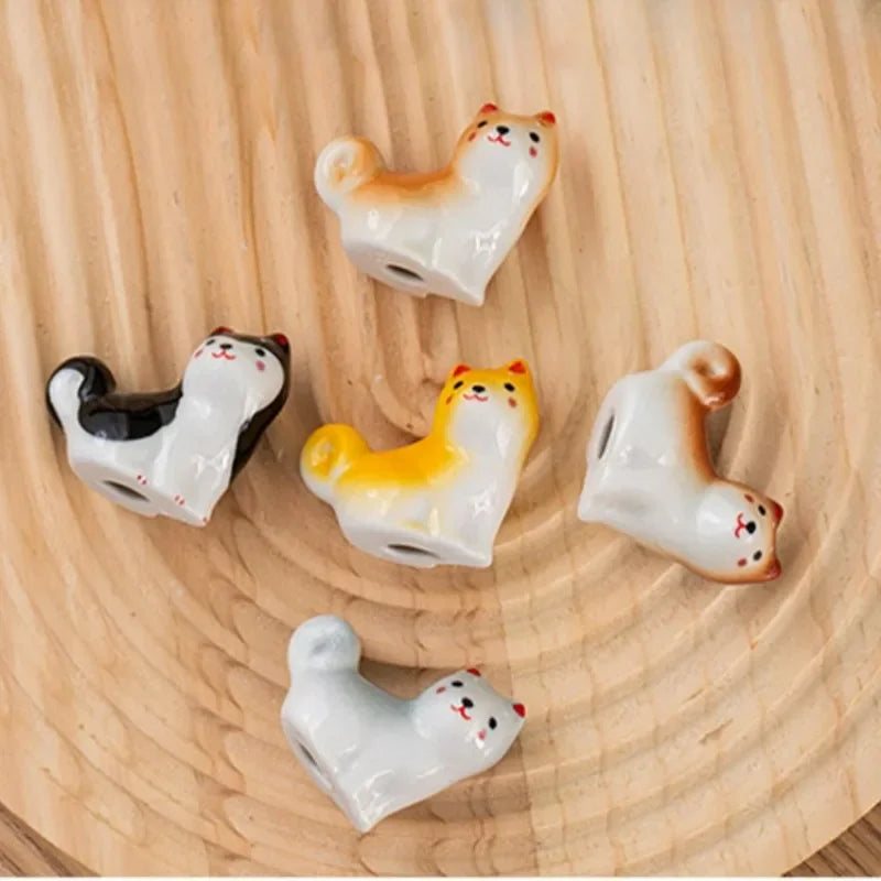 Five small ceramic kawaii animal figurines on a wooden surface