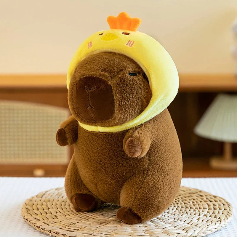Kawaii plush toy resembling a brown animal with a yellow helmet and orange crown on a woven mat.