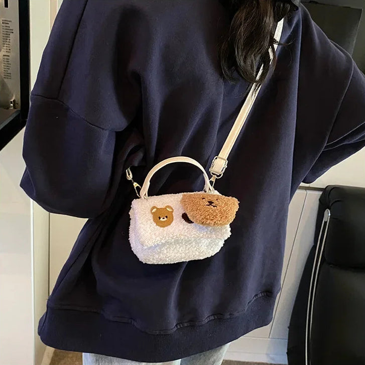 Person wearing a navy blue hoodie with a small white bag featuring Kawaii bear faces on it.