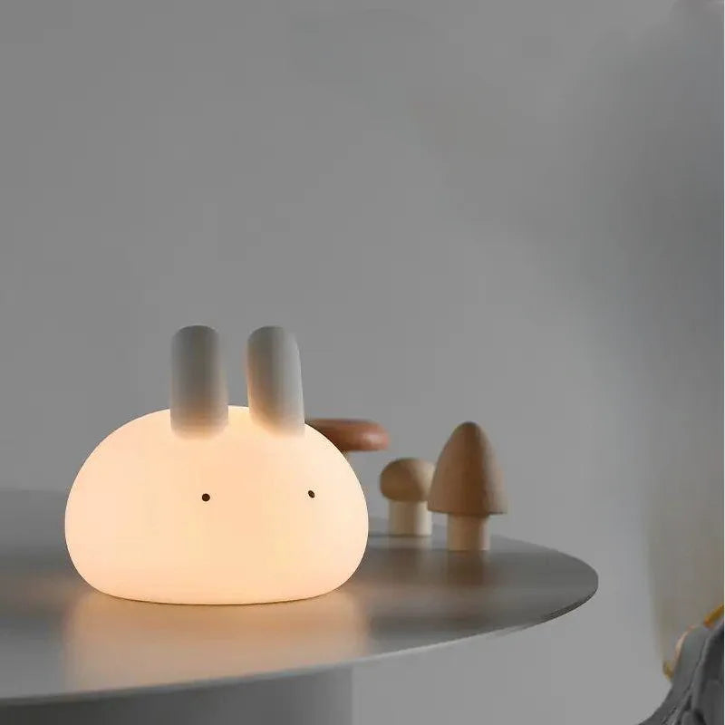 Cute rabbit-shaped kawaii night light on a table with a neutral background