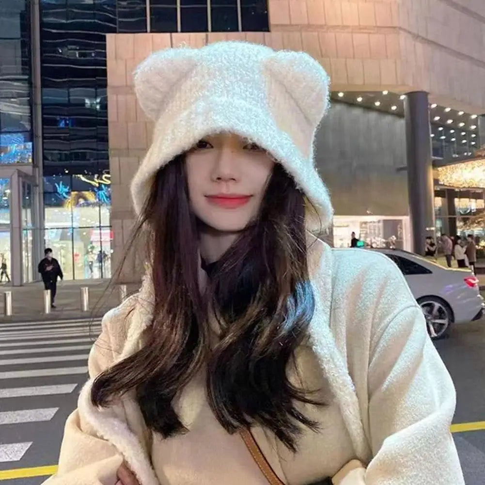 Woman wearing a fluffy hooded Kawaii coat and hat with bear ears on a city street.