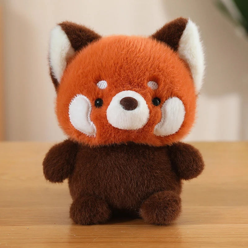 Plush kawaii toy red panda on a wooden surface with a blurred background