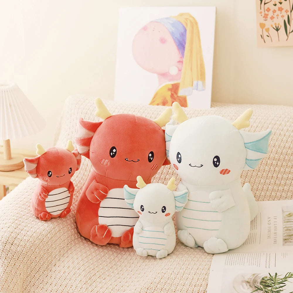 Set of cute dragon kawaii plush toys on a couch with a soft, neutral background.
