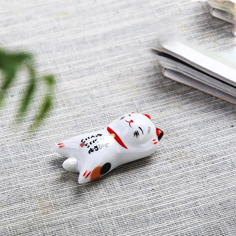 Small ceramic kawaii cat figurine on a textured surface