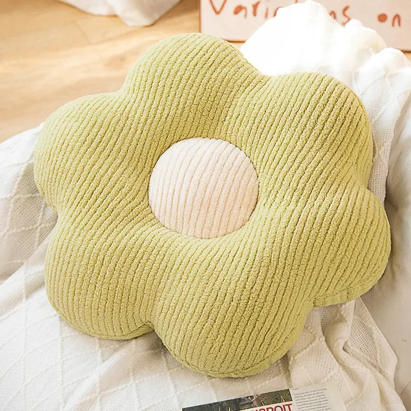 Green cloud-shaped kawaii pillow on a bed with white bedding