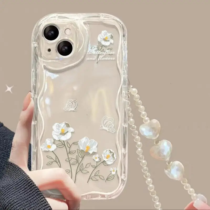 Clear phone case with kawaii floral design and chain holder held by a person.