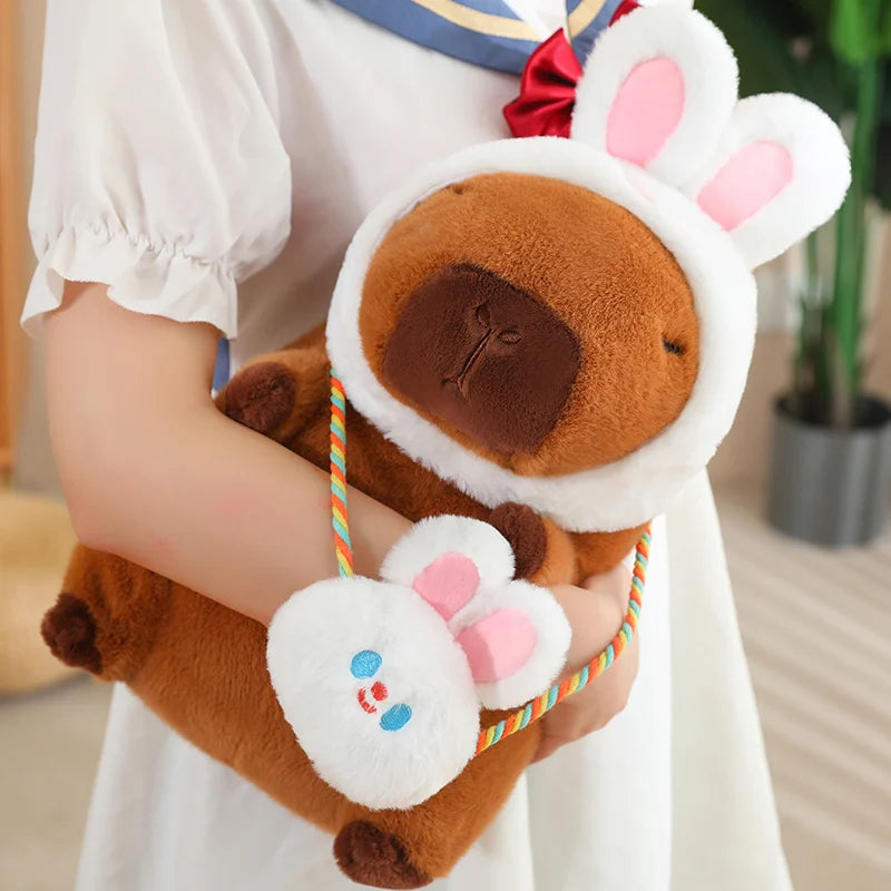 Kawaii plush toy resembling a dog with bunny ears held by a person in a white outfit.