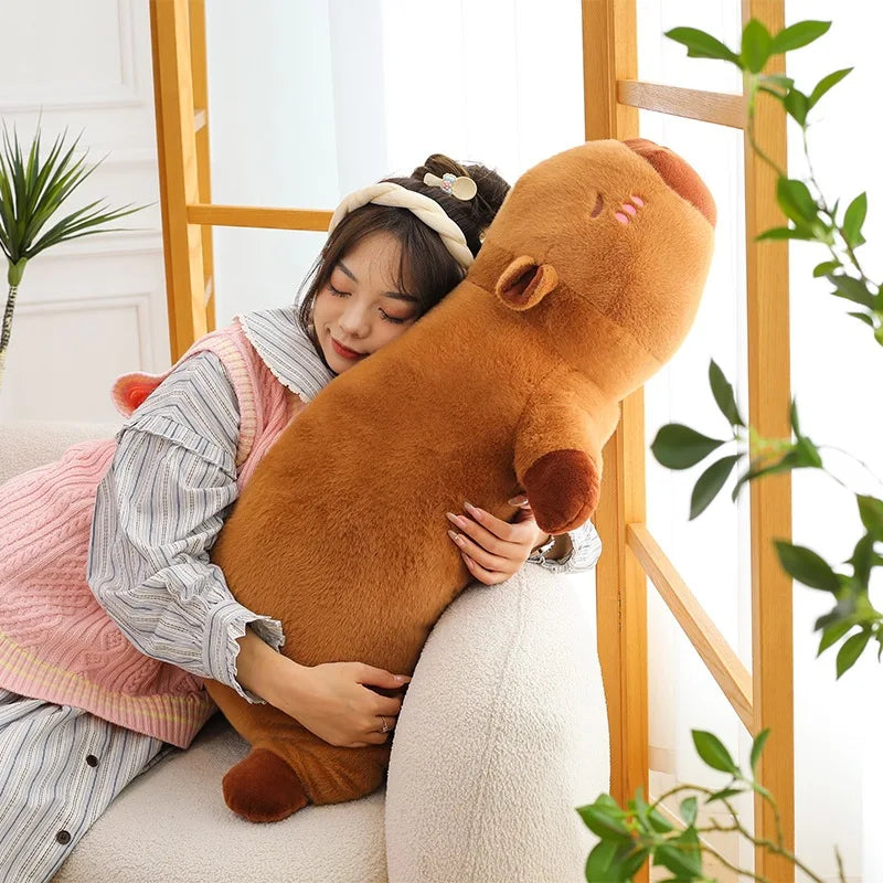 Person hugging a large brown kawaii plush toy in a bright room with plants.