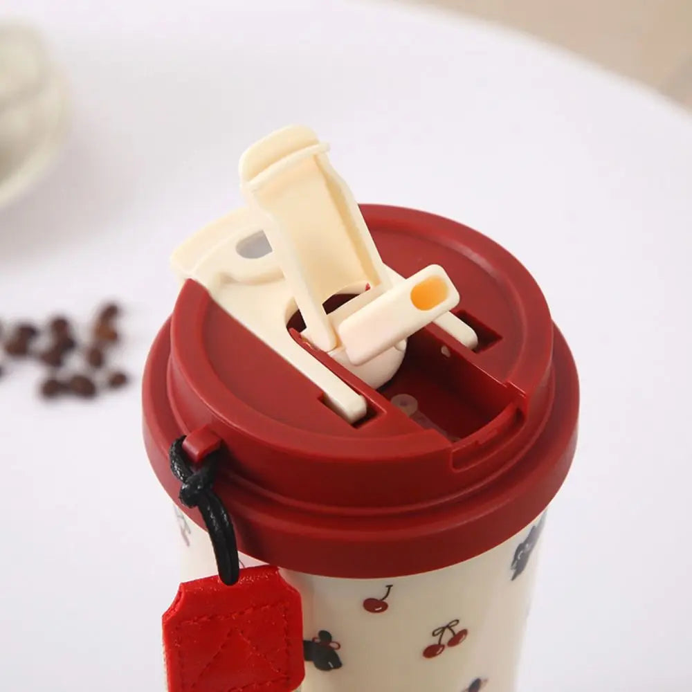 Red lid with a white handle on a Kawaii cup against a blurred background