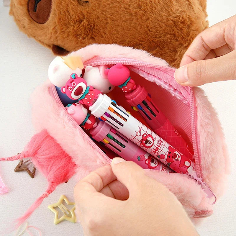 Pink kawaii pencil case with stationery items and a plush toy in the background