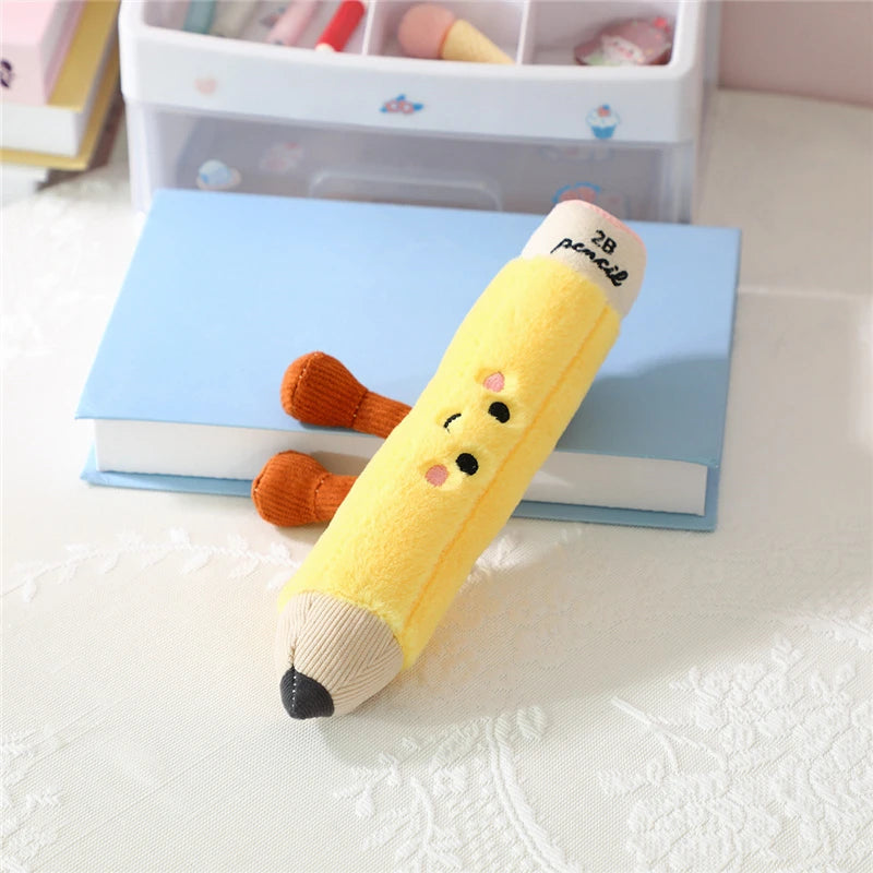 Kawaii plush toy shaped like a yellow pencil with a face on a white surface