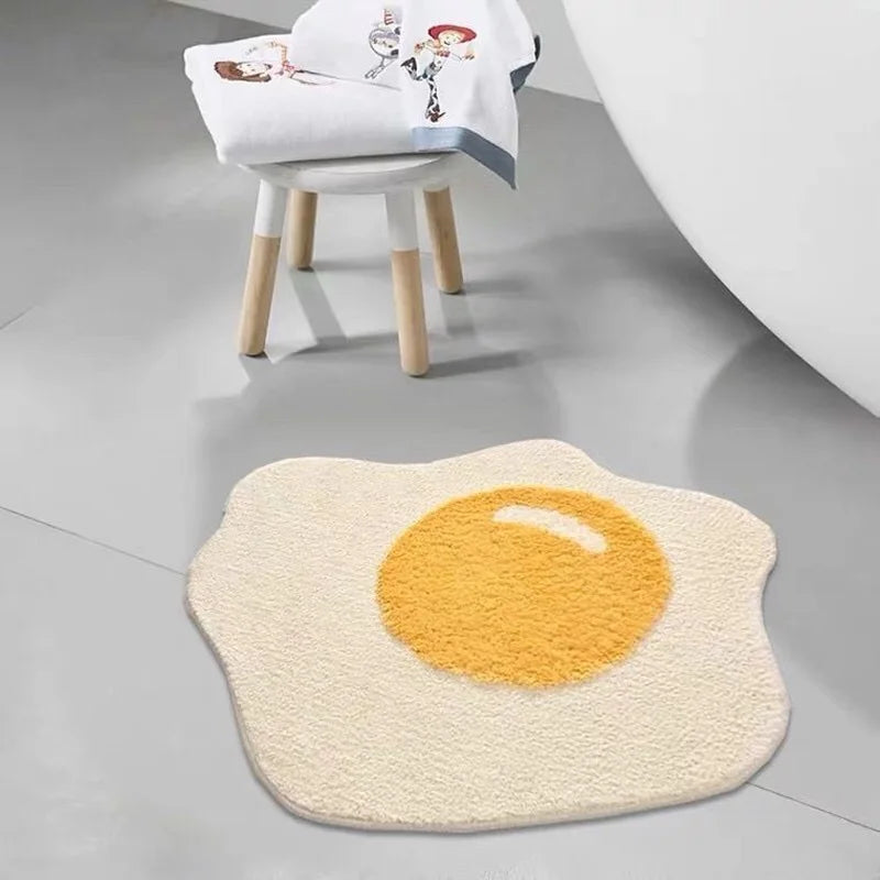 Round kawaii bath mat shaped like a fried egg on a bathroom floor.