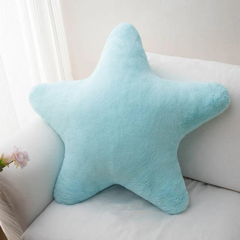 Star-shaped light blue kawaii pillow on a white couch with a light background