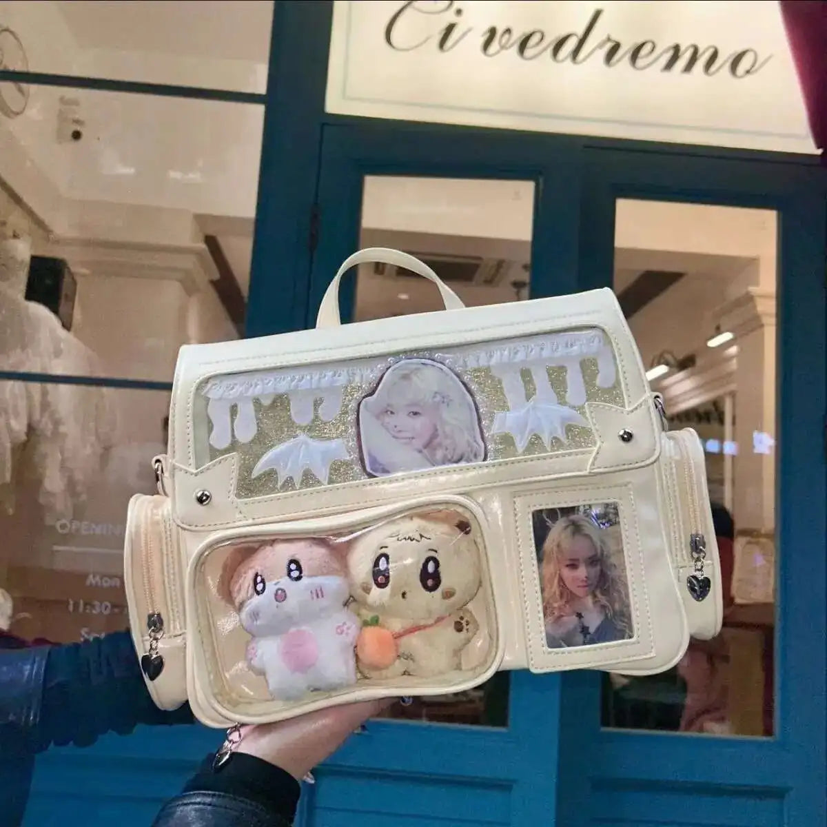 Handbag with Kawaii cartoon characters and a person's face printed on it, held in front of a store entrance.