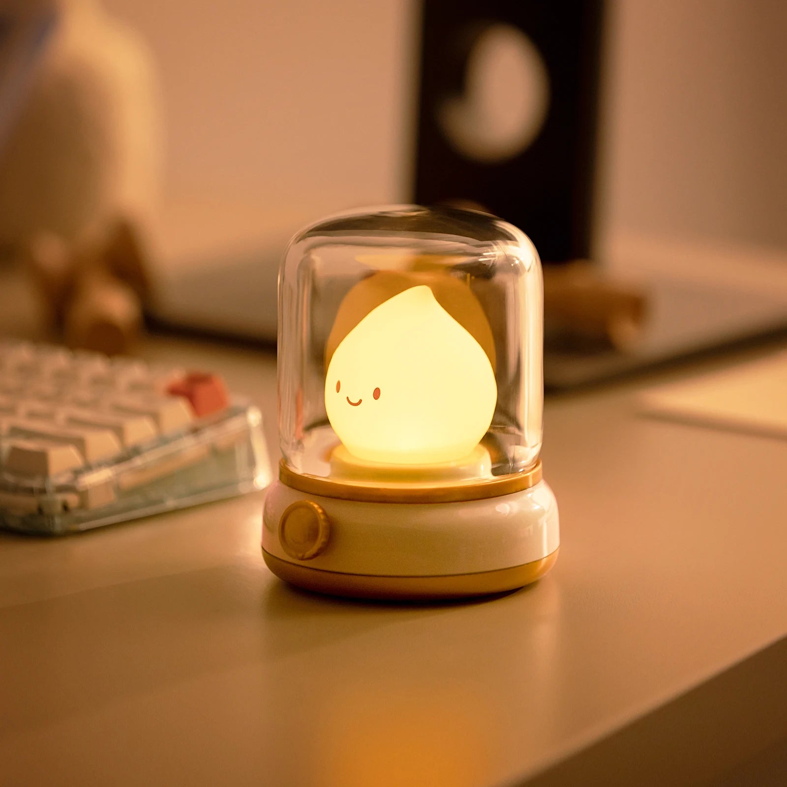 Cute kawaii night light with a smiling face in a glass dome on a desk.