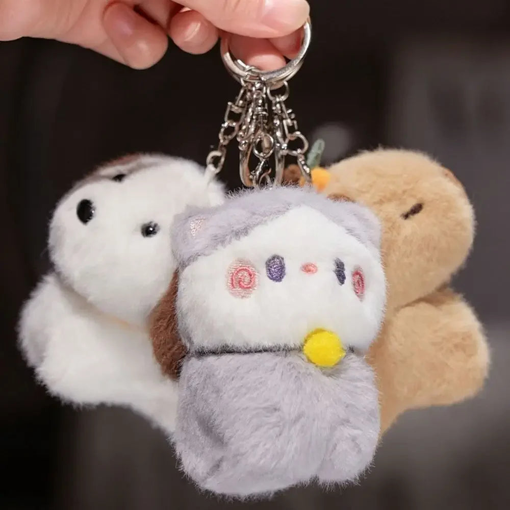 Plush keychain with three kawaii  characters on a dark background