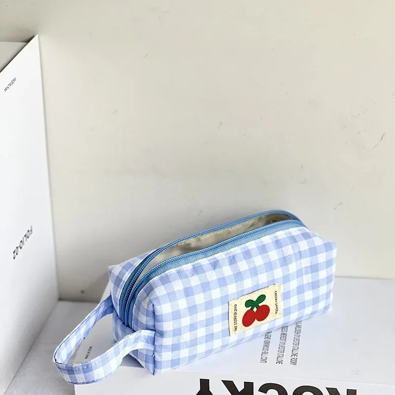 Blue and white checkered kawaii pouch with a cherry design on a white surface