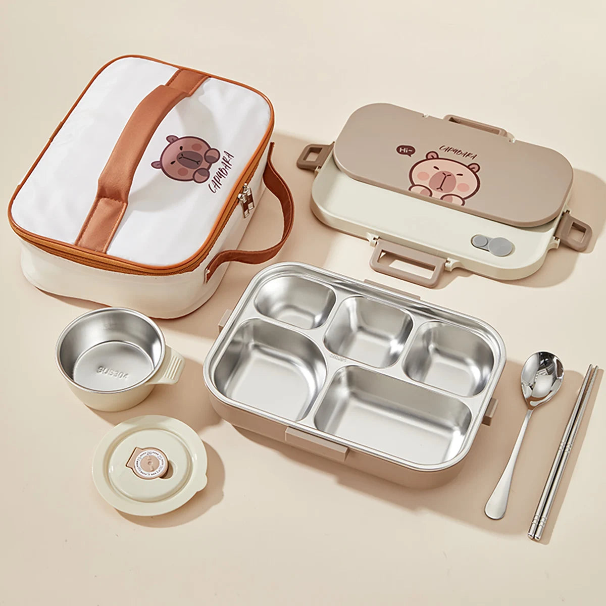 Kawaii lunch box set with compartments, lid, and utensils on a beige background