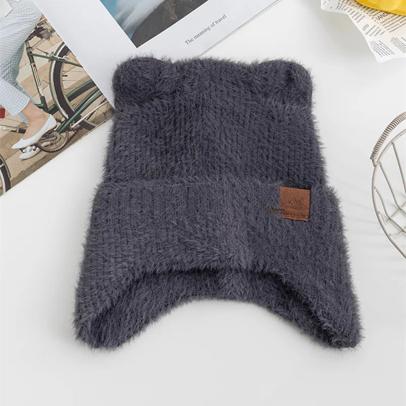 Gray knitted Kawaii hat with a brown label on a white surface