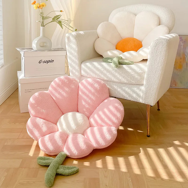 Kawaii flower-shaped pink cushion on a wooden floor with a white chair in the background.